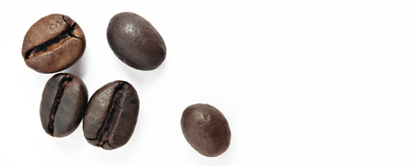 Shiny freshly roasted coffee beans on a white background. Isolated. Banner