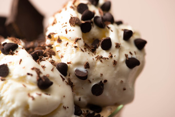 Selective focus of ice cream with chocolate morsels on beige background