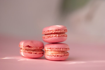 Pink colorful macaroons tasty french cookies beautiful macro food photo with shiny sun rays light. Stylish mood