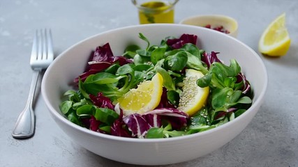 step by step of preparing a fresh salad with olive oil and lemon juice. Valerian leaves, radicchio salad and sesame seeds in a white bowl. fitness salad for lunch and dinner. home cooking diet recipe