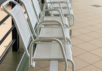 Seats in the waiting room of the railway station. Metal seats.