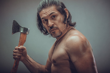 sexy muscular body model portrait of a young man holding an ax in his hands