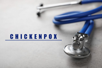 Stethoscope on grey background, closeup. Chickenpox disease