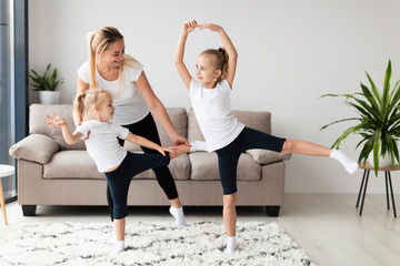 Front view of daughters working out with mother at home