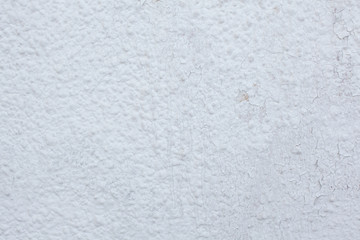 Shabby uneven white painted wall with multiple small cracks texture
