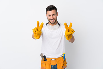 Craftsmen or electrician man over isolated white background smiling and showing victory sign