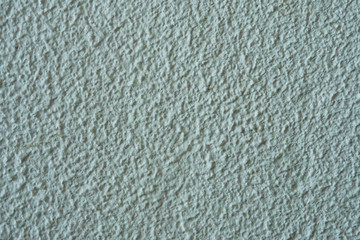 The texture of the plastered white wall with a deep homogeneous structure.