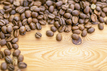 Roasted coffee beans randomly dumped on a wooden table-Close up
