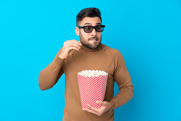 Young handsome man with 3d glasses and holding a big bucket of popcorns