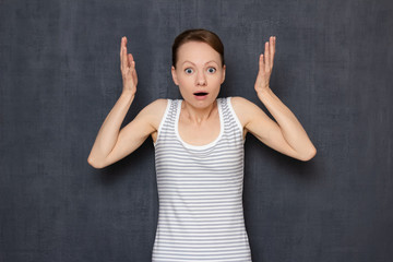 Portrait of shocked surprised woman raising hands up