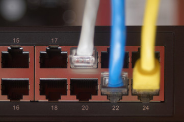 Rack-mount ethernet hub with three colored cable and empty slots