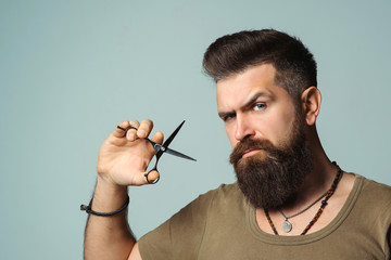 Stylish bearded man. Barber holding scissors. Small business, barber shop. Handsome hairstylist....