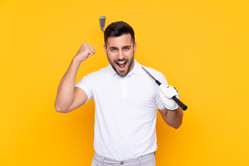 Golfer player man over isolated yellow background celebrating a victory