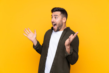 Man over isolated yellow background with surprise facial expression