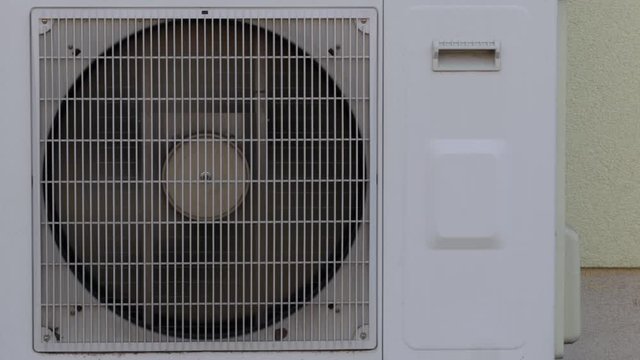 Spinning fan of an outdoor unit of an air conditioning system in the home.