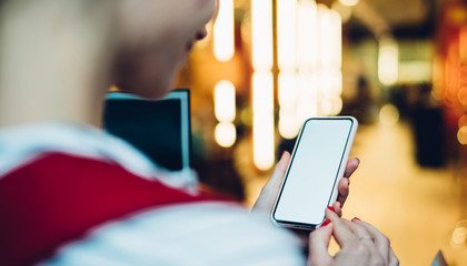 Woman with smartphone against blurry lights