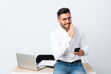 Young businessman holding a mobile phone whispering something