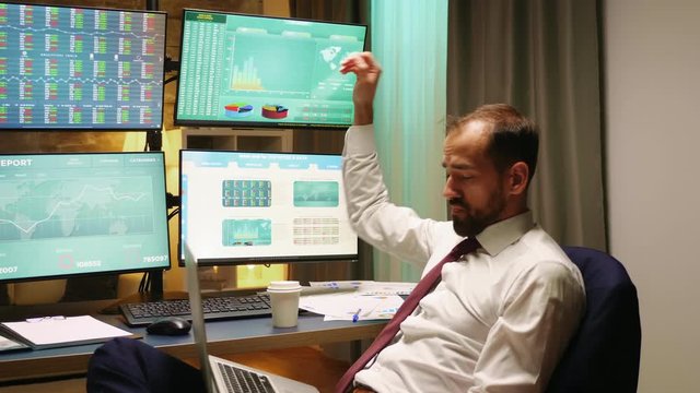 Stock market broker with suit and tie typing on laptop