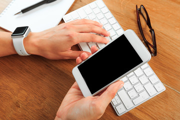 female hands holding smart phone on wooden background  , place for your text
