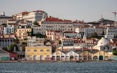 Fototapeta na wymiar The buildings of Lisbon rising from the banks of the Tagus River up through the steep hill streets.