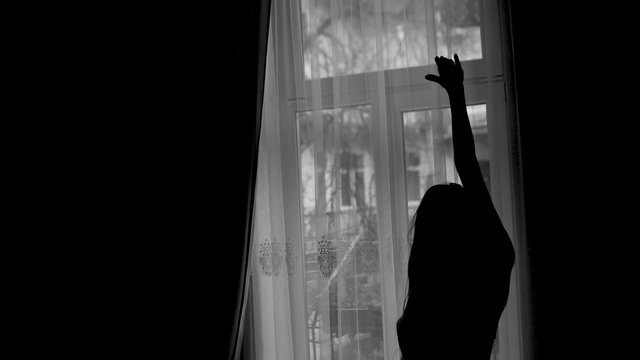 the girl herself dances silhouette in front of the window