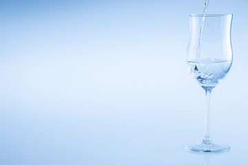 Water poured into a wine glass on an isolated background