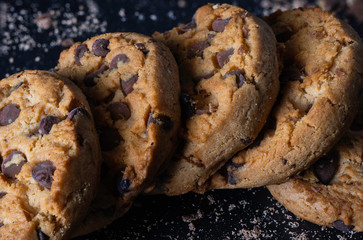 Cookie plate with chocolate chips on a dark rustic background. Sweet concept.