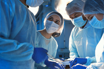 Team of professional surgeons performing operation in clinic