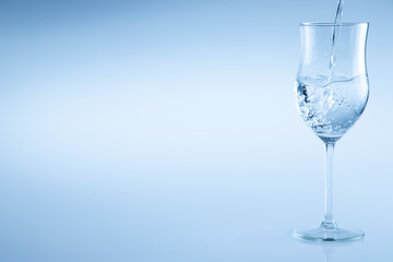 Water poured into a wine glass on an isolated background
