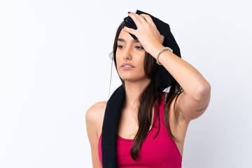 Young sport brunette woman over isolated white background with sport towel