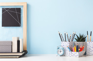 Workspace of student, colorful office supplies and blue wall background. Back to school.