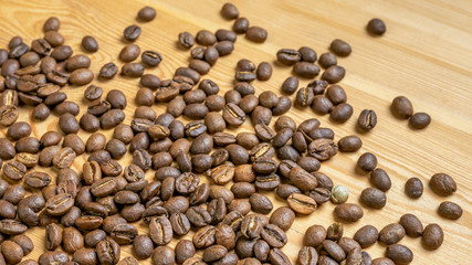 Roasted coffee beans randomly dumped on a wooden table-Close up