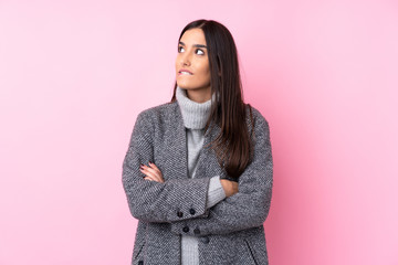 Young brunette woman over isolated pink background with confuse face expression