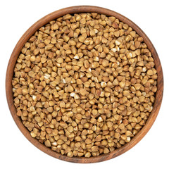 Uncooked buckwheat in wooden bowl isolated on white background. Top view.