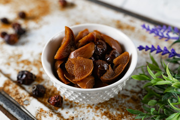 Sweet and soft dried Apple and rose hips prepared for dessert, decorated with a sprig of lavender and dry fruits on an unusual white and rusty metal background