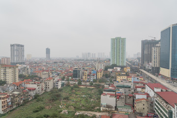 Fototapeta na wymiar Polluted air near under construction elevated highways and skyscrapers in the East of Hanoi