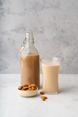 Chocolate almond milk with a bowl of raw almonds. Healthy vegan protein drink. Dairy alternative