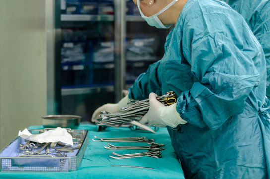 Scrub nurse is preparing medical instruments for operation