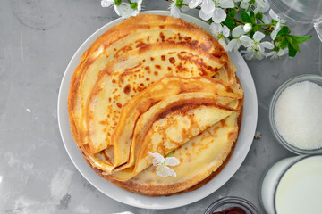 Thin homemade pancakes with berries, pancakes with cherries. Light concrete background. Top view. Tasty sweet breakfast. Traditional English and French crepes. Ingredients. Cooking.