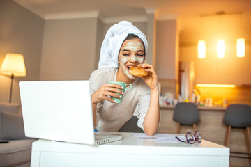 Young modern woman working from home, using laptop in quarantine. Portrait of beautiful cheerful young businesswoman working on laptop and laughing in home office during quarantine