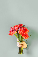 Hand is holding bouquet of flowers.