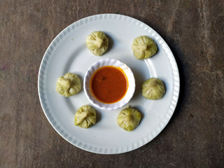 some fresh eatable food put in a plate with red chutney