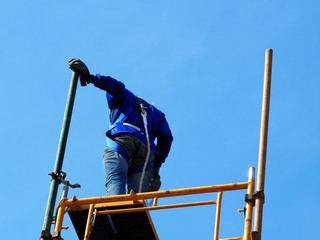 Construction workers working on scaffolding,Man Working on the Working at height with blue sky at construction site