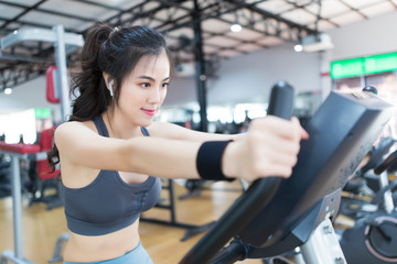 Asia woman are exercising by cycling in gym.