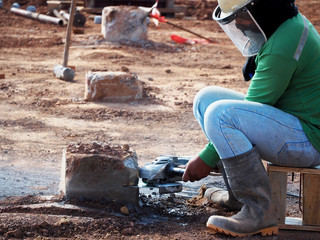 Worker grinds the concrete of angular grinding machine