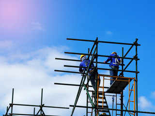 Construction workers working on scaffolding,Man Working on the Working at height with blue sky at...