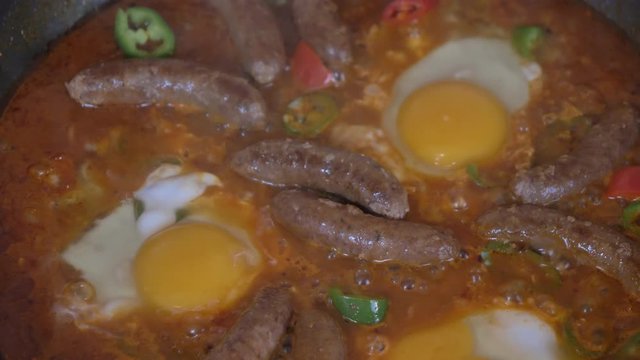 Close up shot of wiener sausages and egg on the grill slow motion