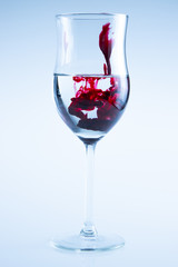 Powerful color splash in wine glass. Red ink, glass isolated.