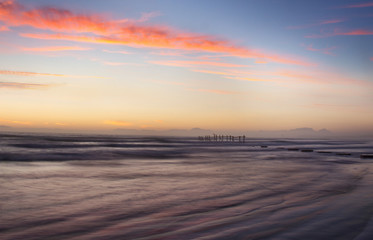 Fototapeta na wymiar A sunset over a pier in the ocean