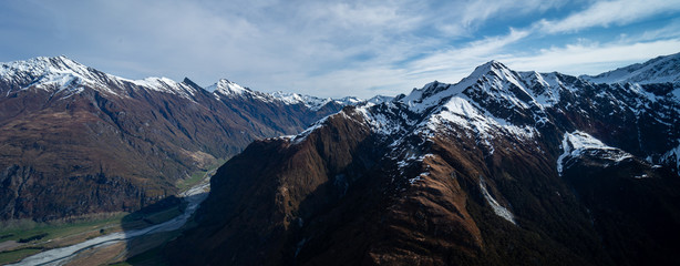 Stunning aerial image of the mouth of the glacier at Lake Wanaka surrounded by snow capped...